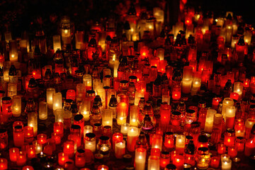 Fototapeta na wymiar Candles in the cemetery. 1st November. Feast of All Saints. Hallowmas. All Souls' Day.