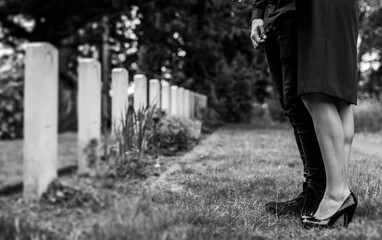 Couple standing together by a gravestone