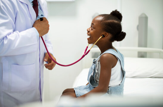 Friendly pediatrician entertaining his patient