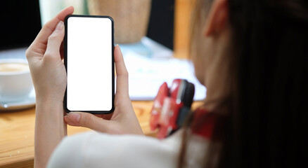 Woman holding mock up smart phone happy browsing internet on smartphone gadgets at home..