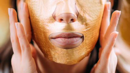 Woman with Gold Face Beauty Mask
