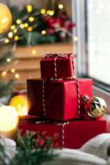 Red gift boxes on a festively decorated windowsill.New Year and Christmas concept.Selective focus.