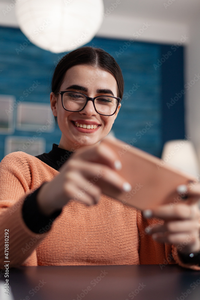Aufkleber smiling student with glasses playing games on smartphone. programmer relaxing while interacting with