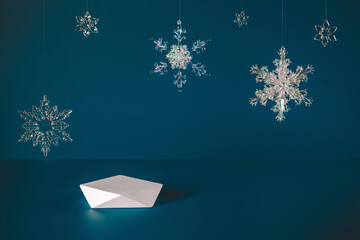 Empty stage white polygonal podium and Christmas snowflakes hanging in the air on blue background...