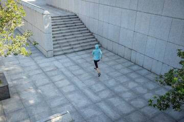 Fitness sports woman running up stairs in city