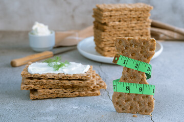 Bread croutons with metric tape measure on a dark background.