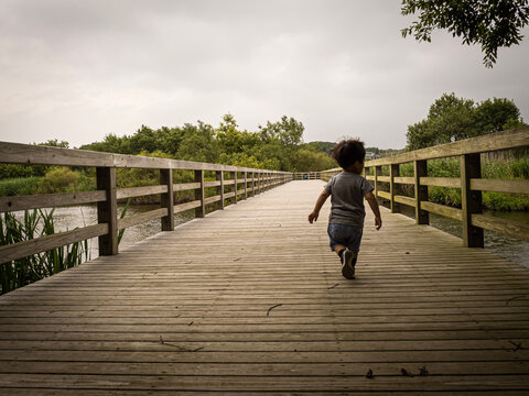 Child running on a bridge - Powered by Adobe