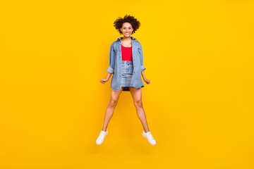 Fototapeta na wymiar Photo of positive cute pretty lady jump wear denim jacket short skirt shoes isolated yellow color background