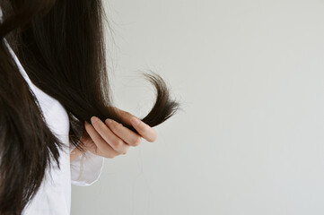 Cropped hand holding dried and sun burnt hair ends