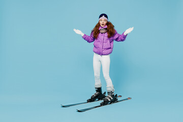Full body skier uncertain confused doubtful woman in warm purple padded windbreaker jacket ski...
