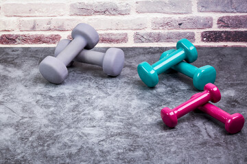 Variety of weights of different colors and weights on a gym floor. Sport concept