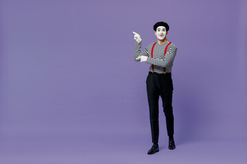 Full size happy young mime man with white face mask wears striped shirt beret point finger aside on workspace area copy space mock up isolated on plain pastel light violet background studio portrait.