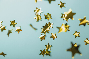 Background with flying gold confetti stars. Blue background. Wallpaper