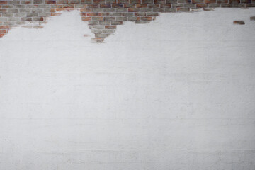 Partially exposed white brick wall