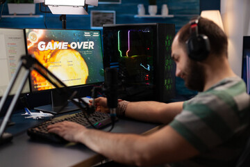 Person losing video games on live stream with chat. Man streaming online gameplay on computer with headset and microphone. Streamer with headphones broadcasting games on social media.