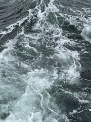 Fototapeta na wymiar Vertical shot of beautiful waves on deep blue ocean waters