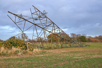 Fallen electricity pylon in a field - obrazy, fototapety, plakaty