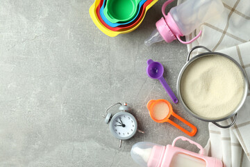 Concept of baby food with рowdered milk on gray textured background