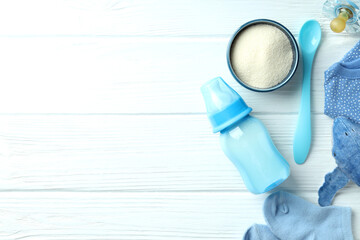 Concept of baby food with рowdered milk on white wooden background