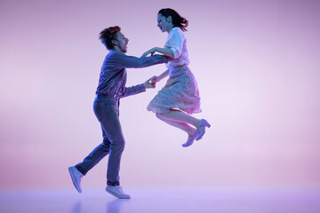 Two young graceful dancers, man and woman in vintage style outfits dancing rock-and-roll isolated...