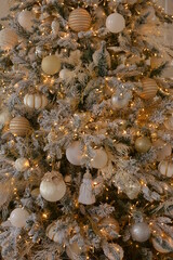 Trendy luxury christmas tree decorated in golden and white colors. Christmas decorations close up. Happy New Year and Merry Christmas!