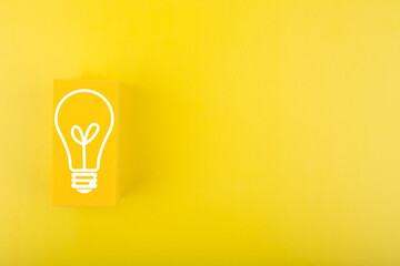 Creativity, innovation and idea concept. Light bulb drawn on yellow rectangle on yellow background with copy space