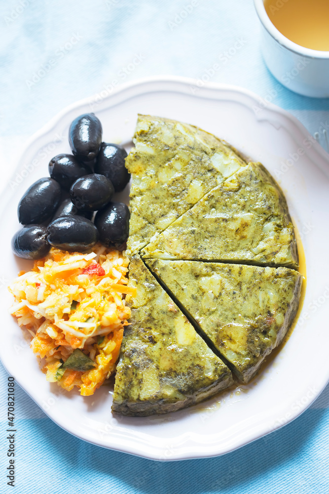 Wall mural Spinach potato tortilla with vegetable salad and black olives