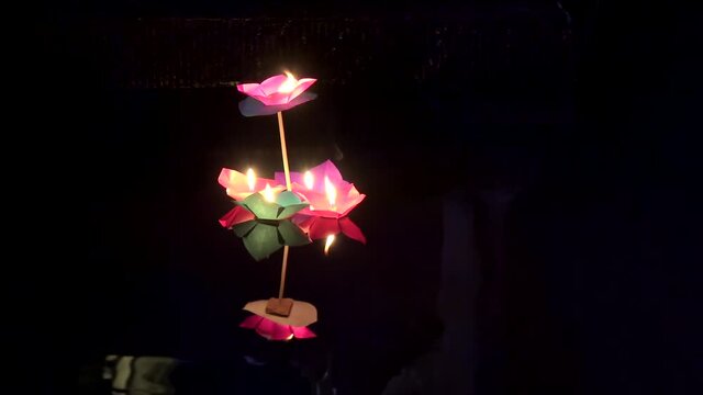 Paper flowers with burning candles float on Tuojiang River at night. Fenghuang, Xiangxi, Hunan, China