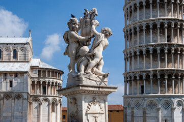 Fototapeta na wymiar Pisa, Toscana. Gruppo scultoreo con Putti tra l' abside del Duomo e la Torre Pendente.