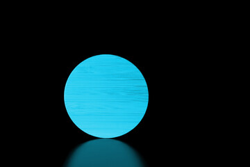 Close-up blue round textured wooden shape on black background with reflection.Low key.Copy space for text.Product placement room.Horizontal banner.Minimalism.Concept of supermoon or sun in darkness