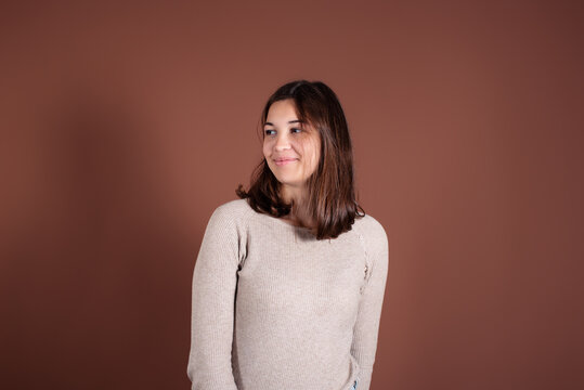 Portrait of a beautiful woman. Cute girl on a brown background.