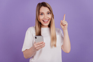 Positive crazy lady hold telephone direct finger up empty space have idea isolated on violet color background