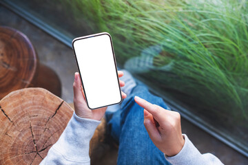Top view mockup image of a woman holding mobile phone with blank desktop screen