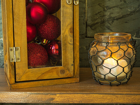 Lantern full of Christmas balls next to illuminated lantern