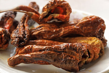 Dry hot pepper fries on white background .