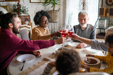 Happy multiethnic multigeneration family having fun together around kitchen table.