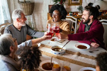 Happy multiethnic multigeneration family having fun together around kitchen table.