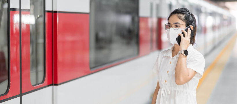 woman using smartphone during wearing protective face mask in train. public transportation, technology and safety under covid-19 pandemic