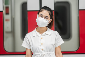 Fototapeta na wymiar happy woman with Protective face mask prevention coronavirus inflection during waiting train. public transportation. social distancing, new normal and safety under covid-19 pandemic