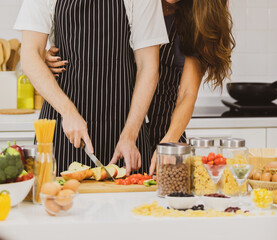 Cheerful couple cooking in kitchen