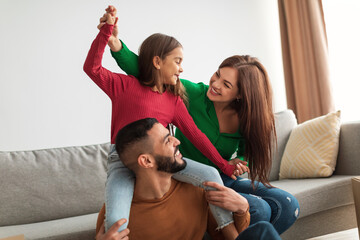 Portrait of happy Arab family playing, having fun at home