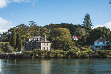 Naklejka premium Vintage photo of an old stone storehouse on the river bank. Toned image