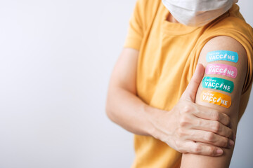 woman showing plaster after receiving covid 19 vaccine. Vaccination, herd immunity, side effect,...