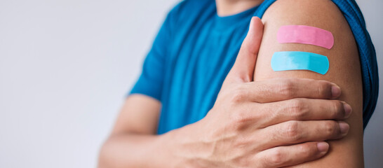 Man showing plaster after receiving covid 19 vaccine. Vaccination, herd immunity, side effect, booster dose, vaccine passport and Coronavirus pandemic