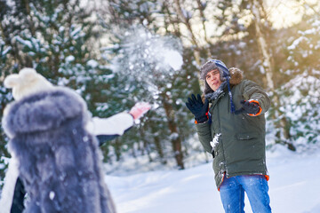 Fototapeta na wymiar Couple having fun in winter scenery and snow