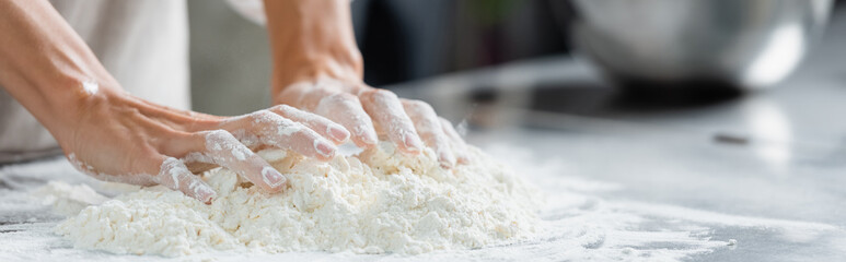 Fototapeta premium Cropped view of chef making dough on restaurant kitchen, banner