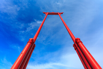 The giant swing on the background of the sky and clouds 