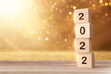 wooden cubes with the text 2022 over bright shiny background