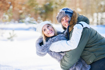 Obraz premium Couple having fun in winter scenery and snow