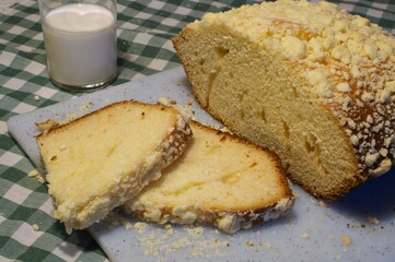 Homemade yeast dough on a cutting board standing next to a glass of milk.